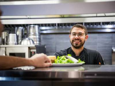Chef serving a plate at the counter